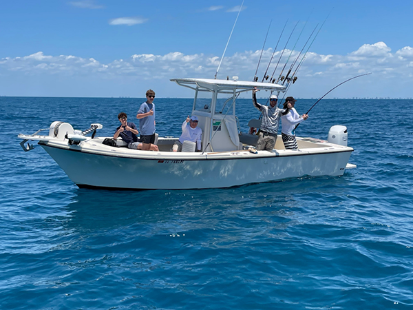 Charter boat floating in the Gulf of America with people fishing.