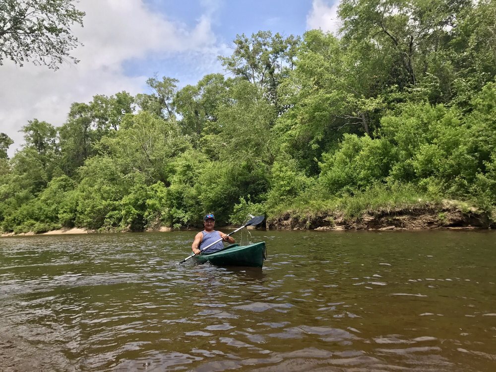 Kayak on the river with trees in the background.